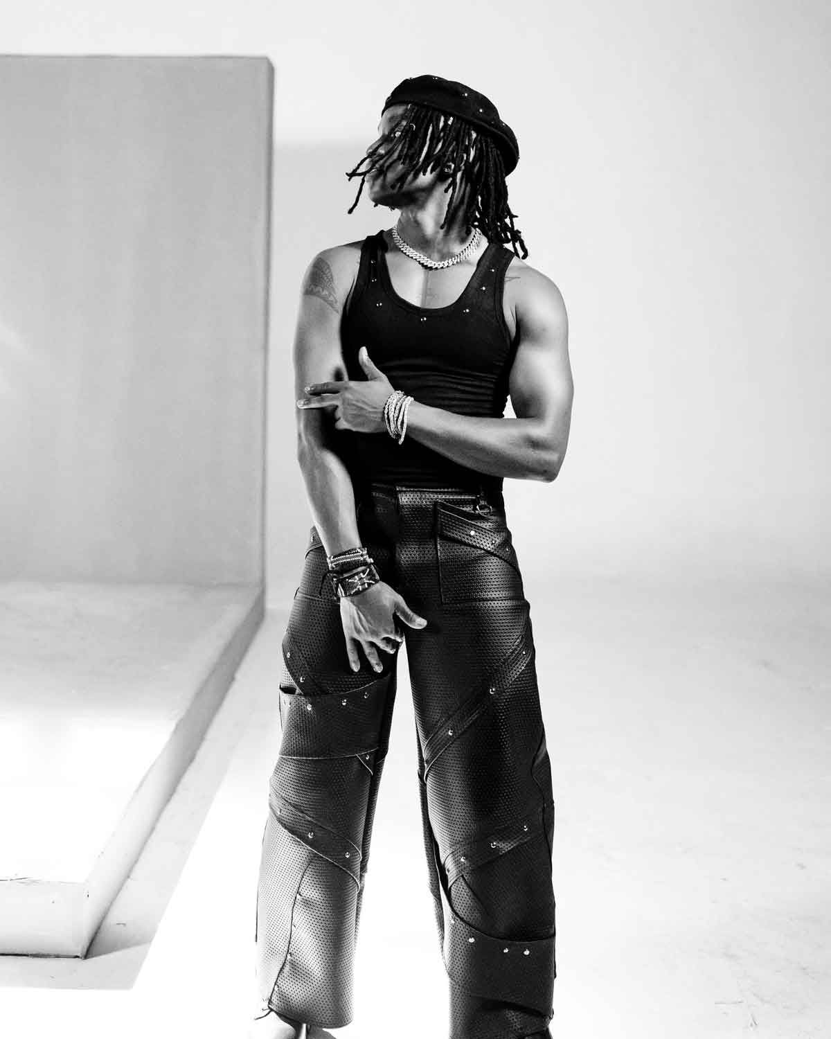 A man wearing a black leather pants inside a studio