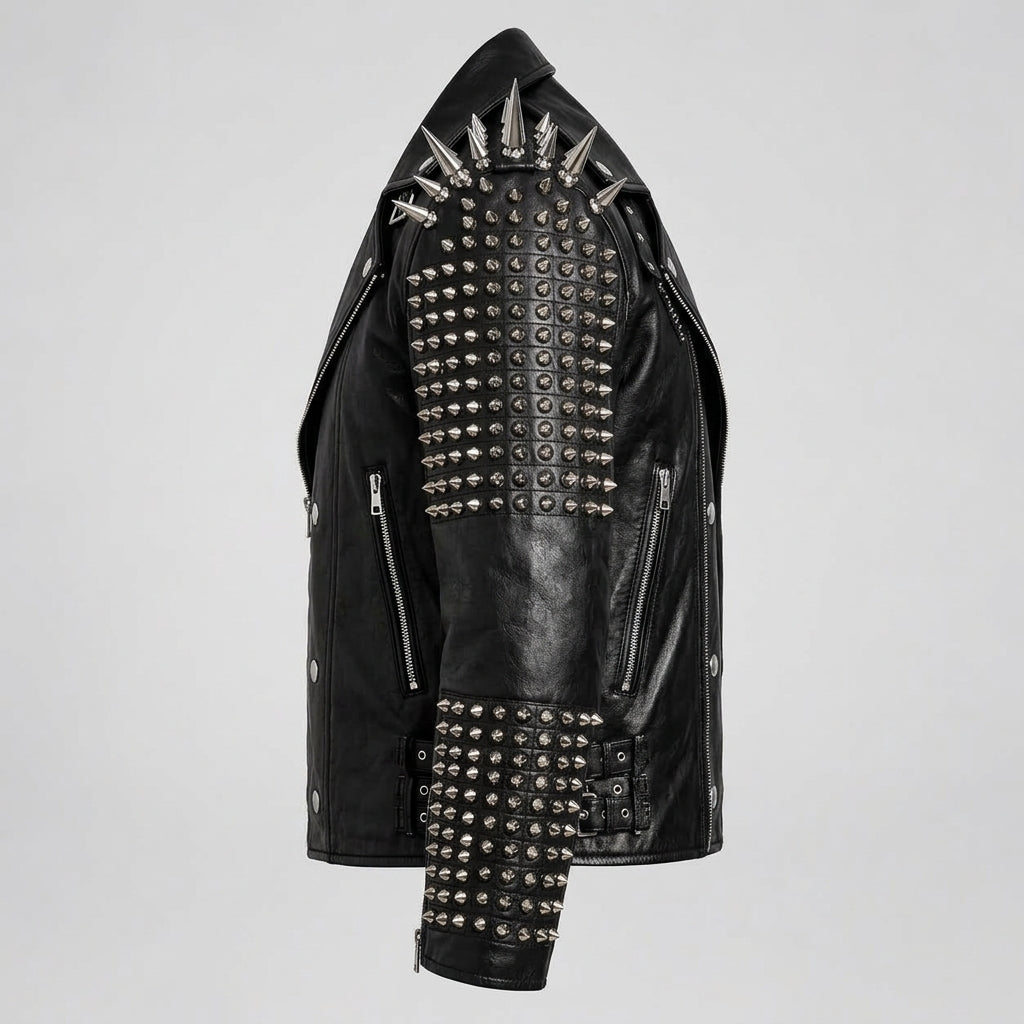 A black leather motorcycle jacket heavily embellished with silver spikes and studs, shown against a plain light gray background.