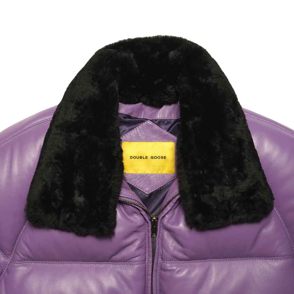 Close-up of a lilac v bomber jacket with a black fur collar and a yellow Double Goose brand label inside the collar.