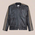 A vintage track jacket with beige stripes down the sleeves, displayed flat against a solid beige background.