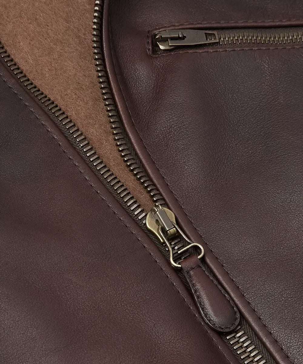 Close up of a jacket with antique brass zipper closure and a chest pocket with zipper closure