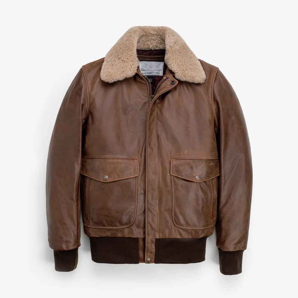 A brown Mens Bomber Jacket with Fur Collar with a thick beige shearling-style collar, featuring a front zipper, two large flap pockets, and ribbed knit cuffs and hem, shown against a plain white background.