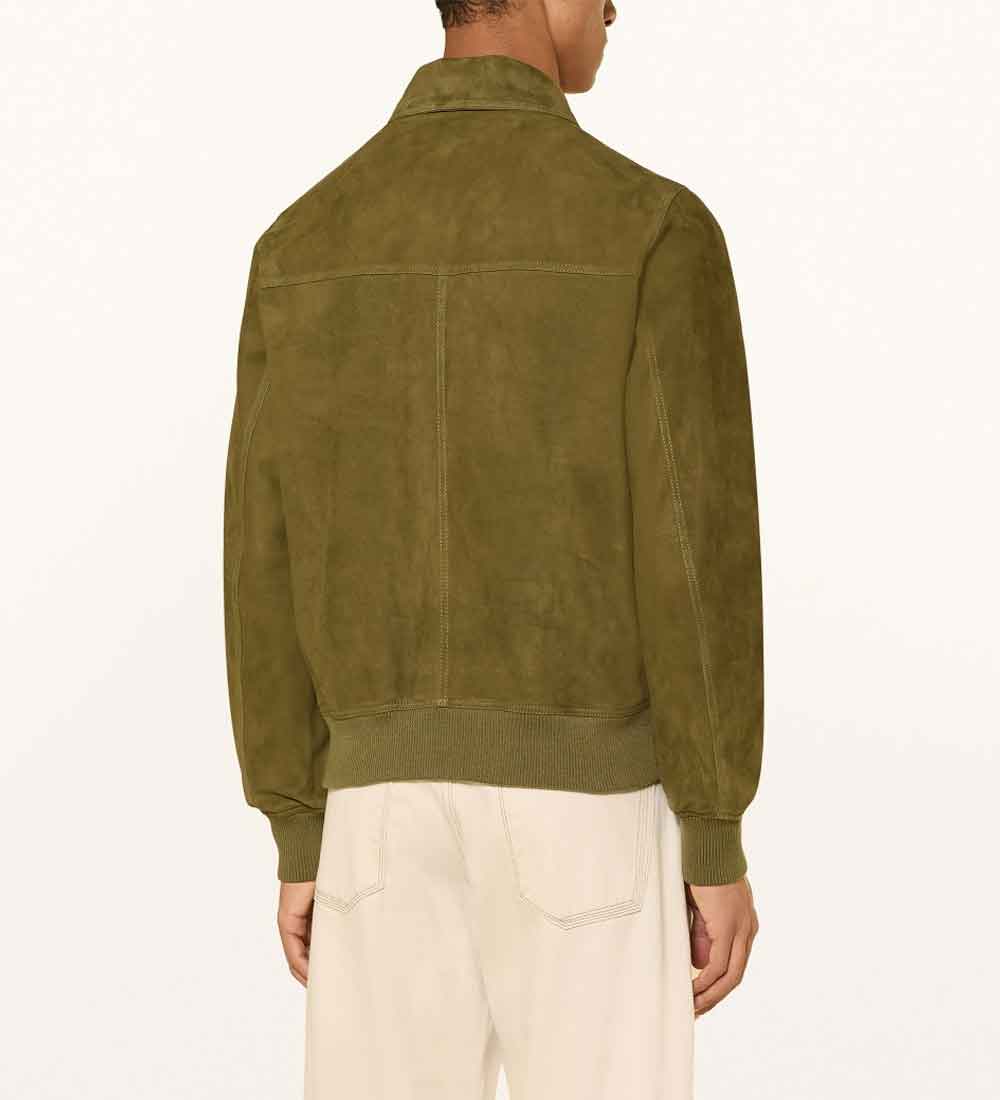 A man viewed from the back wearing an olive green suede jacket and off-white trousers, set against a plain white background.