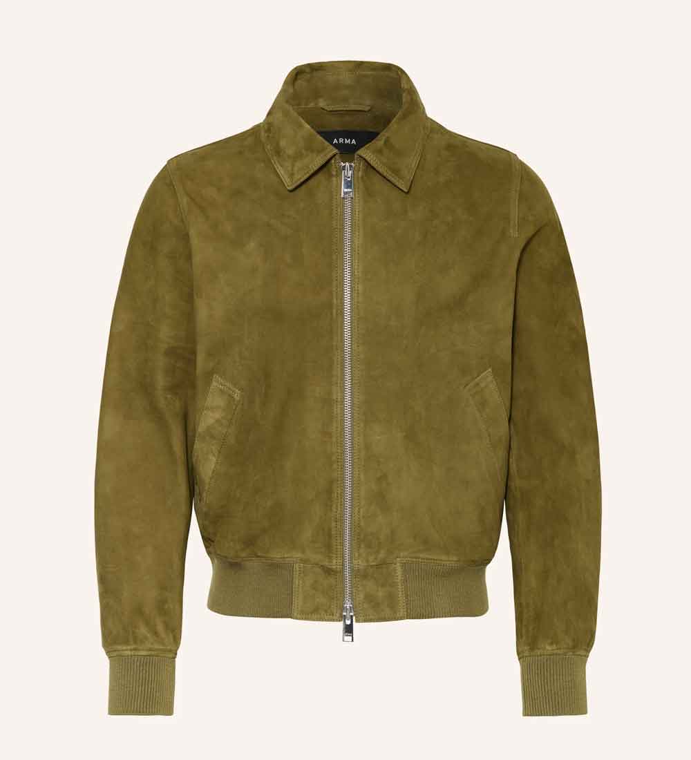 An olive green suede bomber jacket with a silver front zipper, ribbed collar, cuffs, and hem, displayed on a clean off-white background.