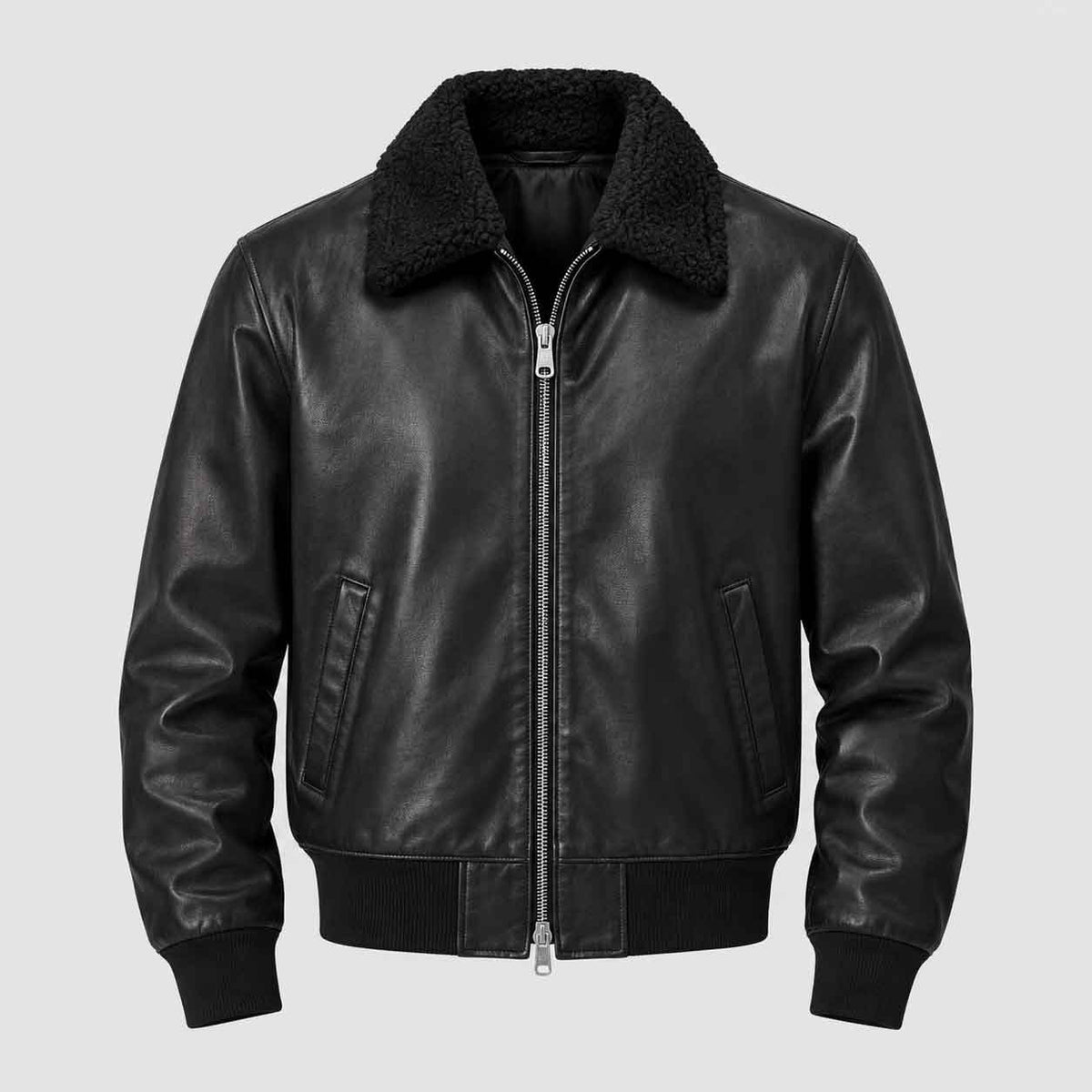 A black leather bomber jacket with a black sherpa collar, front zipper, ribbed cuffs, and ribbed hem, shown against a solid light gray background.