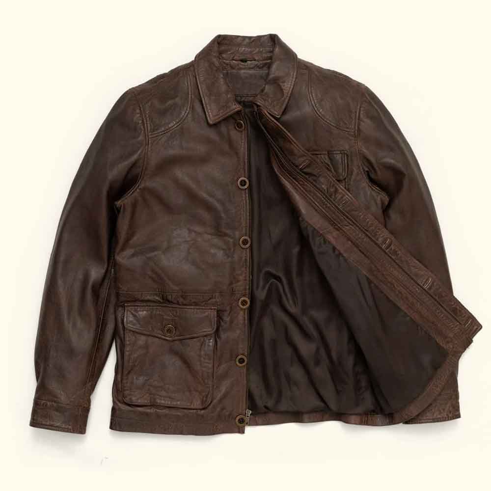 A dark brown Vintage Barn Jacket with a button-up front, collar, and flap pockets, shown laid flat against a light cream background.