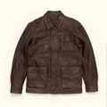 A dark brown Vintage Barn Jacket with a pointed collar, button-up front, and multiple front pockets, laid flat against a light cream background.