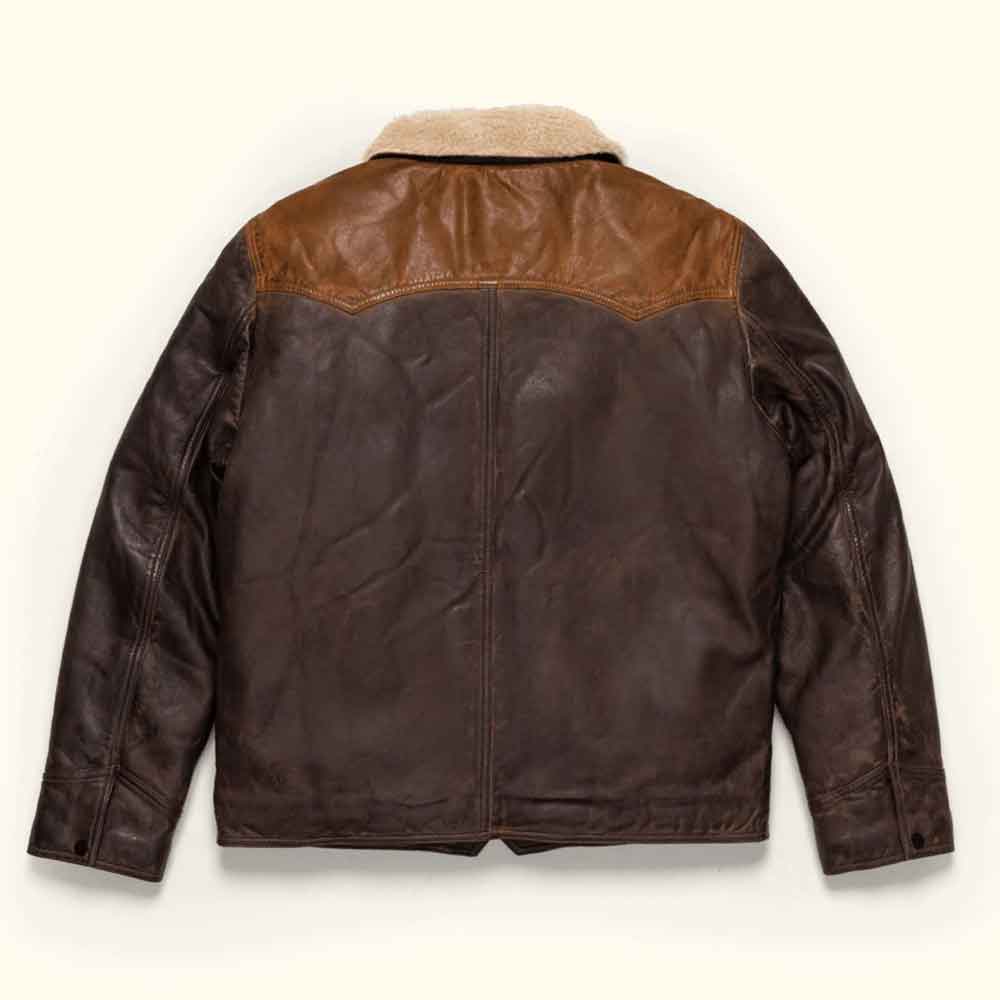 A dark brown leather jacket with a lighter brown leather yoke and a beige shearling collar, shown from the back on a light cream background.