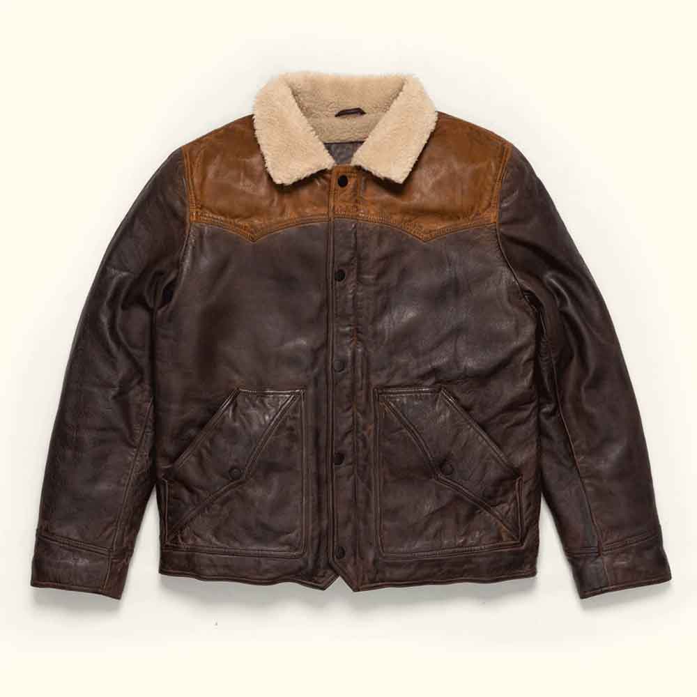 A Vintage Fur Jacket in Sheepskin Leather, a light beige sherpa collar, and front flap pockets, laid flat against a light cream background.