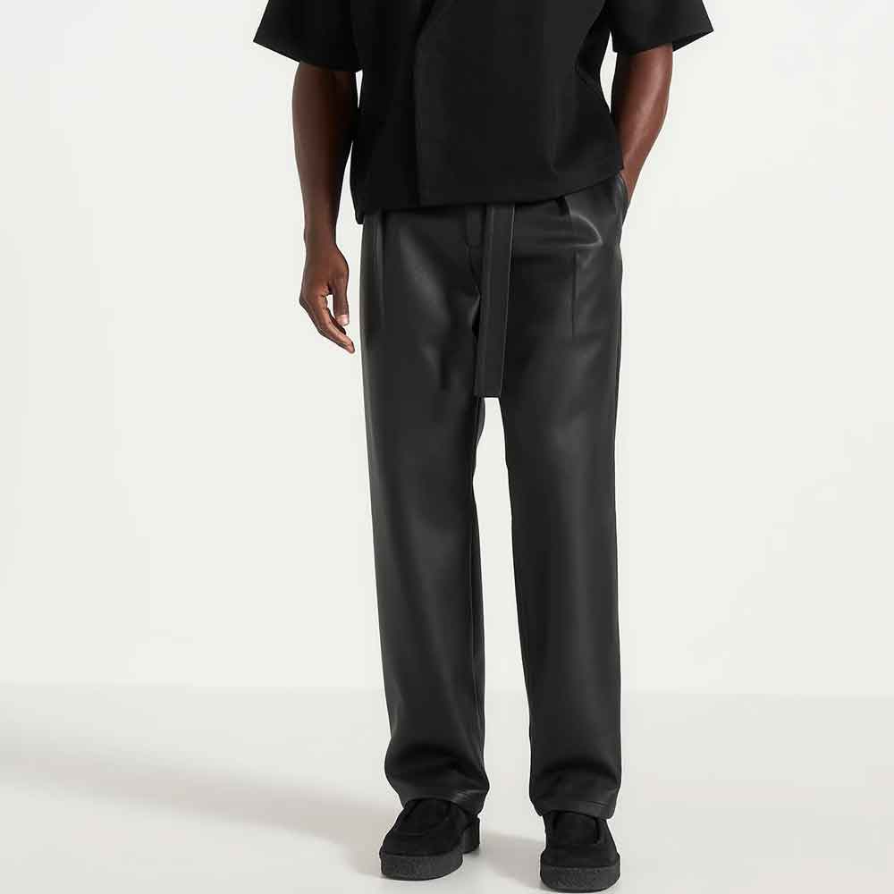 front view of a model wearing wide leg leather pants in black colour